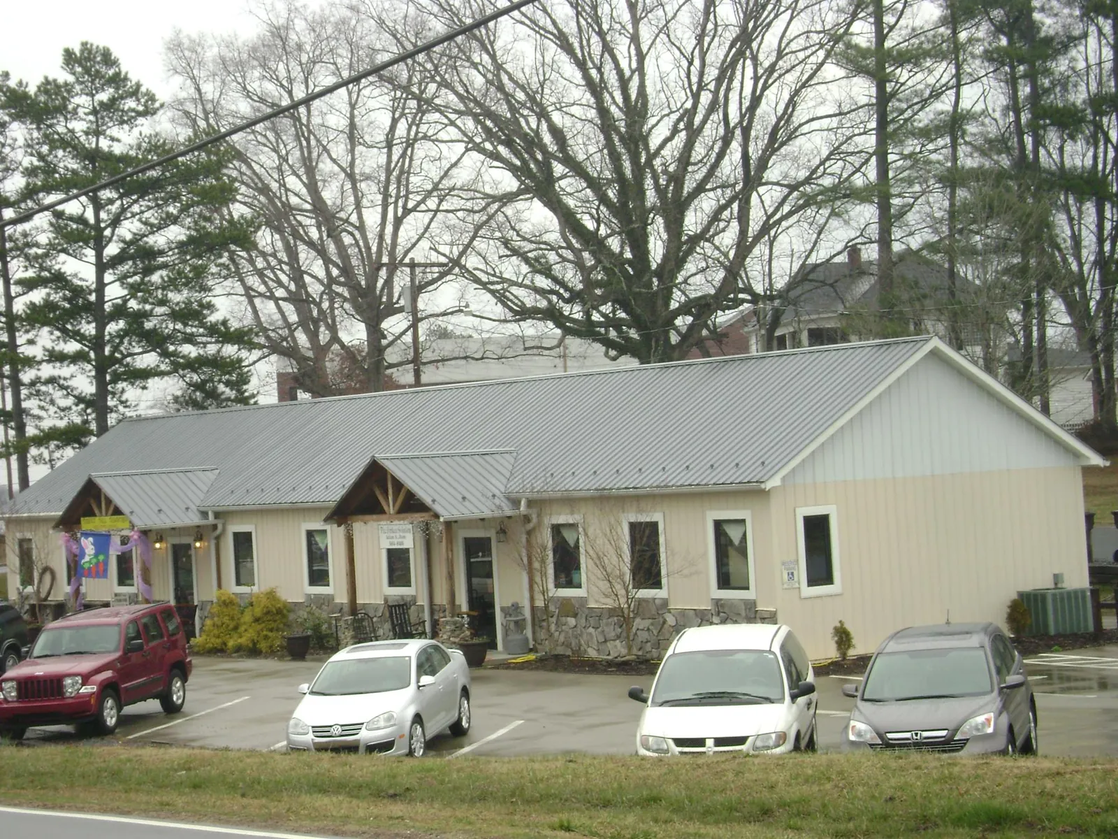 Gray metal roof with timber entry brackets on a small commercial building in Mineral City