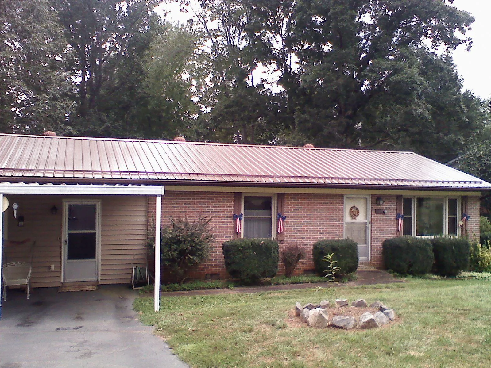Bronze metal roof and carport on a brick ranch home — Roof Repair work by our crew in Mineral City